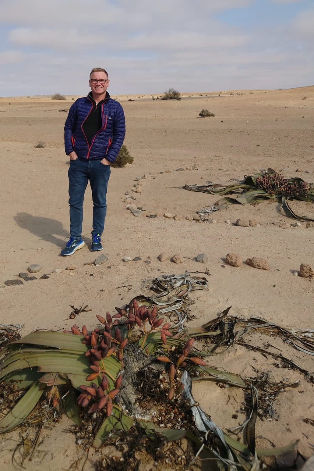 Andrew Hirst in Namibia, with a remarkably long-lived Welwitschia plant